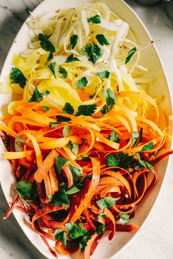 This raw carrot salad with parsnips is a sweet, crunchy and refreshing whole food recipe. It comes together quickly and pairs perfectly with pulled pork and avocado for easy, weeknight paleo tacos. #paleo #whole30 #realfood #wholefood