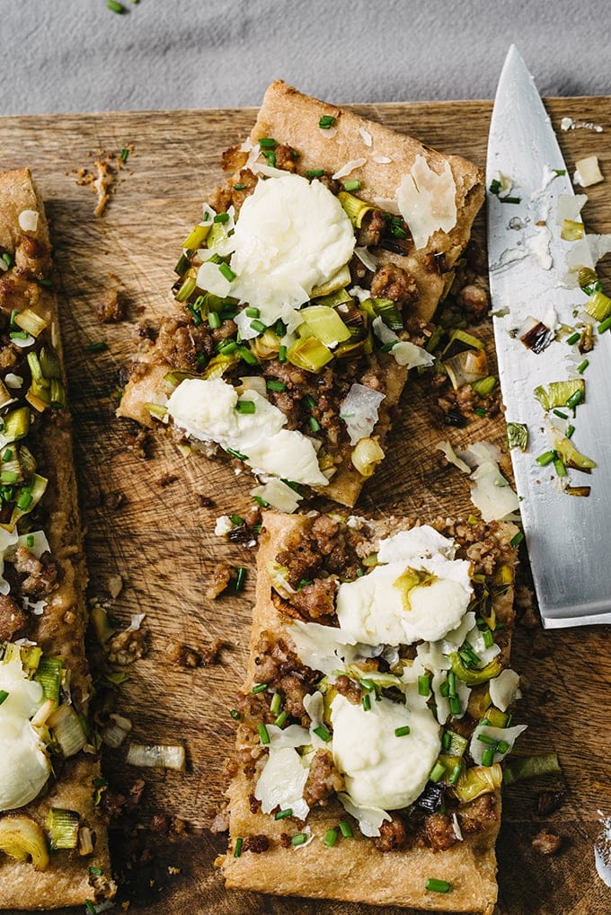 This savory focaccia recipe is an easy crowd pleaser. Layers of ricotta cheese, sweet italian sausage, and caramelized leeks baked atop dense, nutty focaccia bread. It's a super easy, filling, and fun party food. 