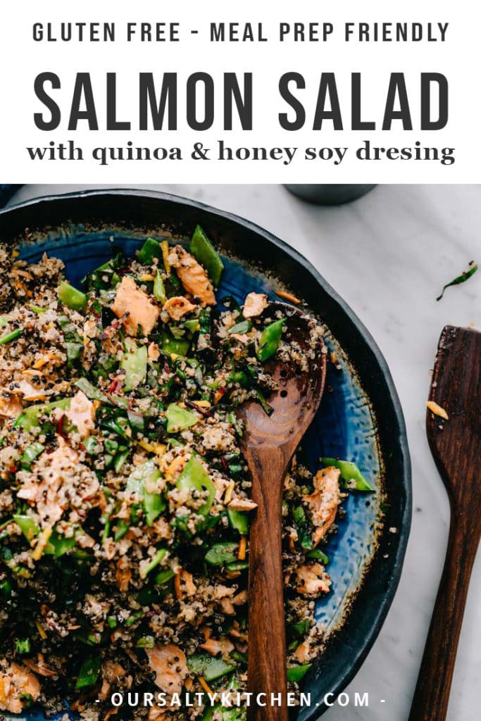 A bowl of salmon quinoa salad with flaked salmon, swiss chard, snap peas, and carrots, finished with a sweet and tangy honey soy vinaigrette.