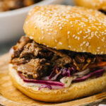 Side view, pulled pork cooked in the oven on a brioche bun with coleslaw.
