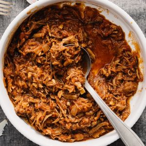 A large white bowl of pulled pork ragu made with leftover pulled pork.
