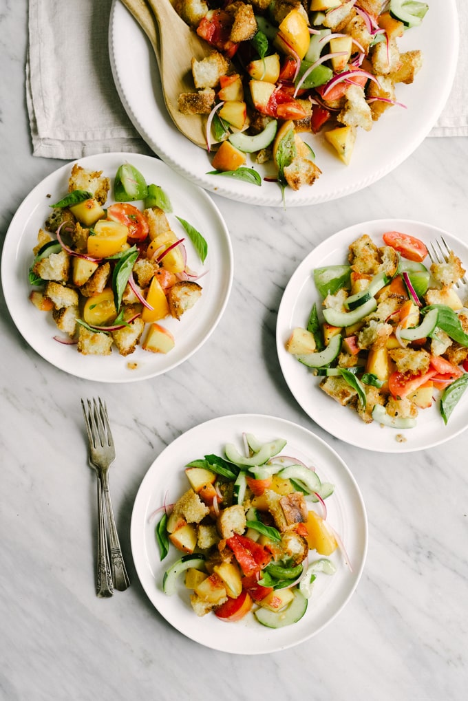 Peach panzanella is the best late summer whole food salad recipe. Juicy peaches and tomatoes, yeasty sourdough, fresh basil, and a champagne vinaigrette make summer produce shine. This is an easy recipe for a packed lunch or light dinner. #healthy #wholefood #realfood #eatclean #cleaneating