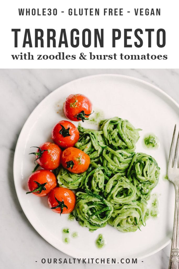 Whole30 tarragon pesto over zucchini noodles with burst tomatoes on white plate.