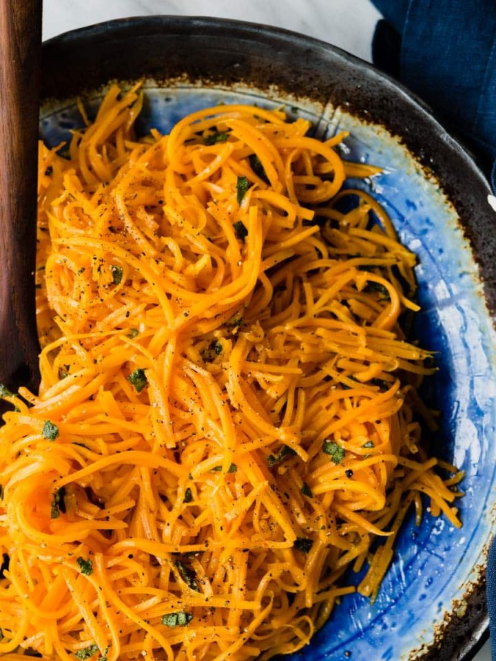 Roasted butternut squash noodles are a vibrant and nutritious fall side dish. They are so easy to make and need only the slightest bit of seasoning to really shine. I love them "naked" as a light lunch or side dish, but they also make for an excellent seasonal pasta substitution. Best of all, this entire dish is ready in just 20 minutes. #grainfree #glutenfree #butternutsquash #noodles #recipe