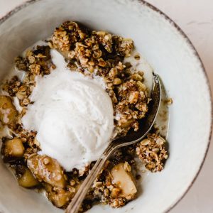 This gluten free apple crisp is a lightened up and refined sugar free version of the fall classic! It's sweetened with maple syrup and coconut sugar, and topped with gluten free oats, pecans, and walnuts. It's made start to finish in a cast iron skillet resulting in an equally tender and crisp texture. This is a healthy fall dessert recipe that will satisfy even the pickiest sweet tooth around your table.