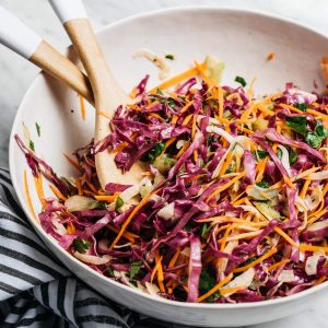 You need this no mayo paleo coleslaw recipe for all your summer potluck plans! It's seasoned with apple cider vinegar and is perfectly tangy. This Whole30 slaw is fast, easy and flavorful, and packed with super healthy vitamins and minerals. Serve it as a side with pulled pork for the perfect summer dinner.