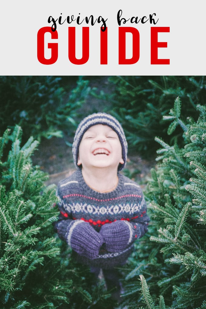 A young boy smiling at a Christmas Tree farm with a call to action for food related charities.