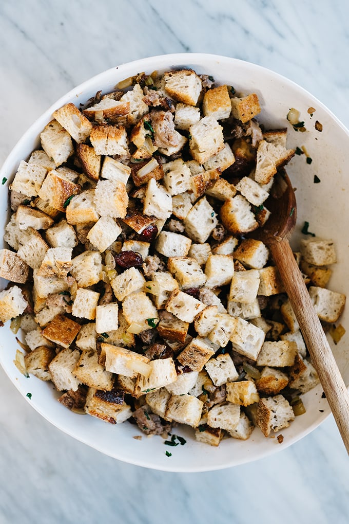 Rye bread croutons with vegetables, fresh herbs, and cranberries for sausage and cranberry stuffing. A savory and mildly sweet Thanksgiving side dish!