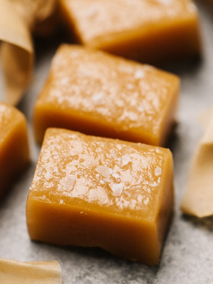 Side view, caramel candy wrapped and unwrapped on a concrete background.