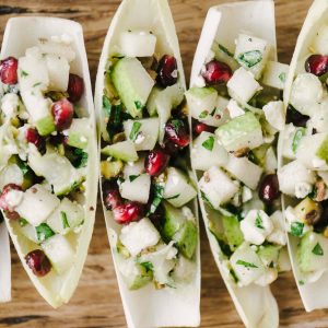 These endive cups are a fast, easy, and healthy holiday party appetizer. They're naturally vegetarian and gluten free, and bursting with flavor. The beautiful green hues and pops of red are seasonal and cheerful. Yum! #glutenfree #vegetarian #appetizer #holidayparty #christmasrecipe #winterrecipe