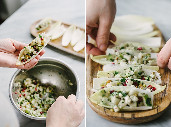 How to make winter harvest endive cups - an easy and fast holiday party appetizer! Spooning stuffing into endive leaves with a raw salad of pear, blue cheese, and pomegranate dressed with a tangy vinaigrette.