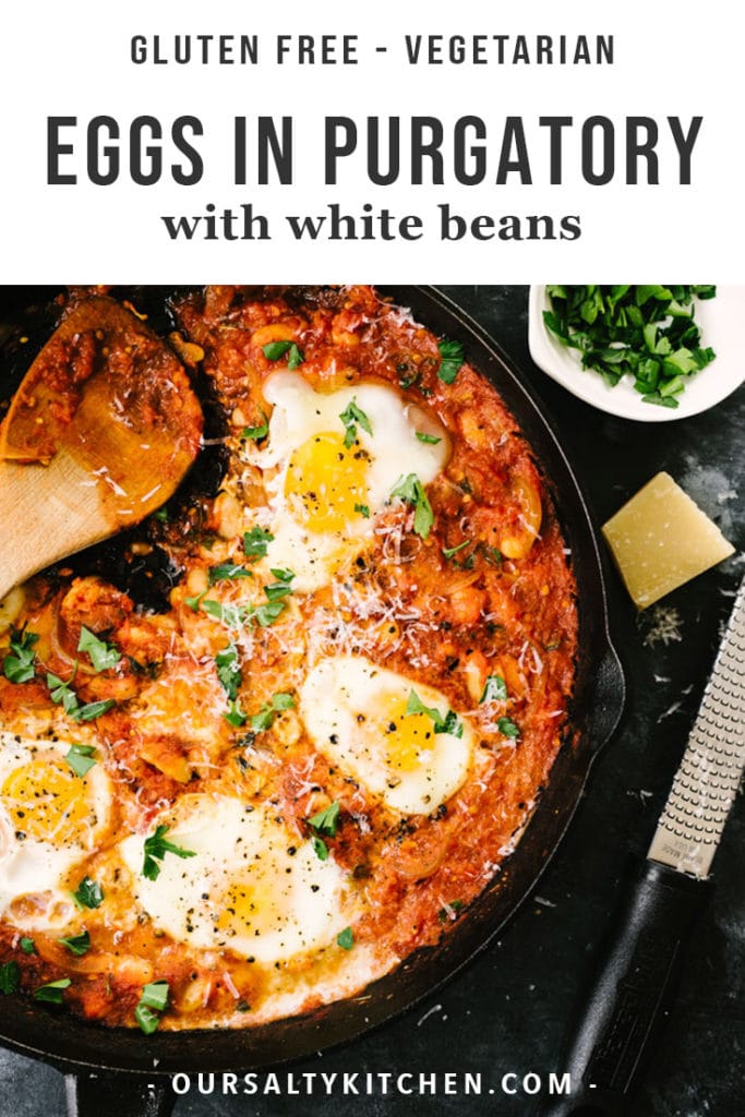 Gluten free white bean eggs in purgatory in a cast iron skillet with herbs and parmesan cheese on the side.