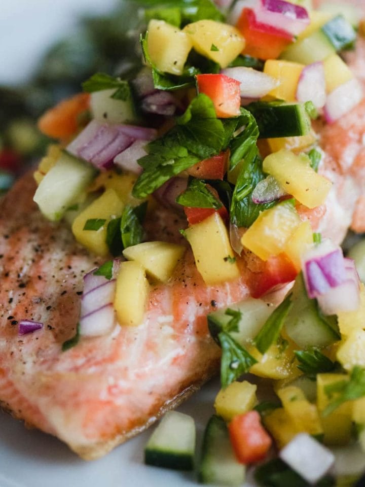 This healthy, colorful cucumber mango salsa is one of my favorite toppings for simple pan-seared wild salmon. It's crunch, tangy, slightly tweet, and perfectly tart. This a fast and easy whole30 recipe that's ready in just 20 minutes! Get the recipe, plus my tips for restaurant perfect seared salmon every single time. Simple and healthy has never tasted so good.