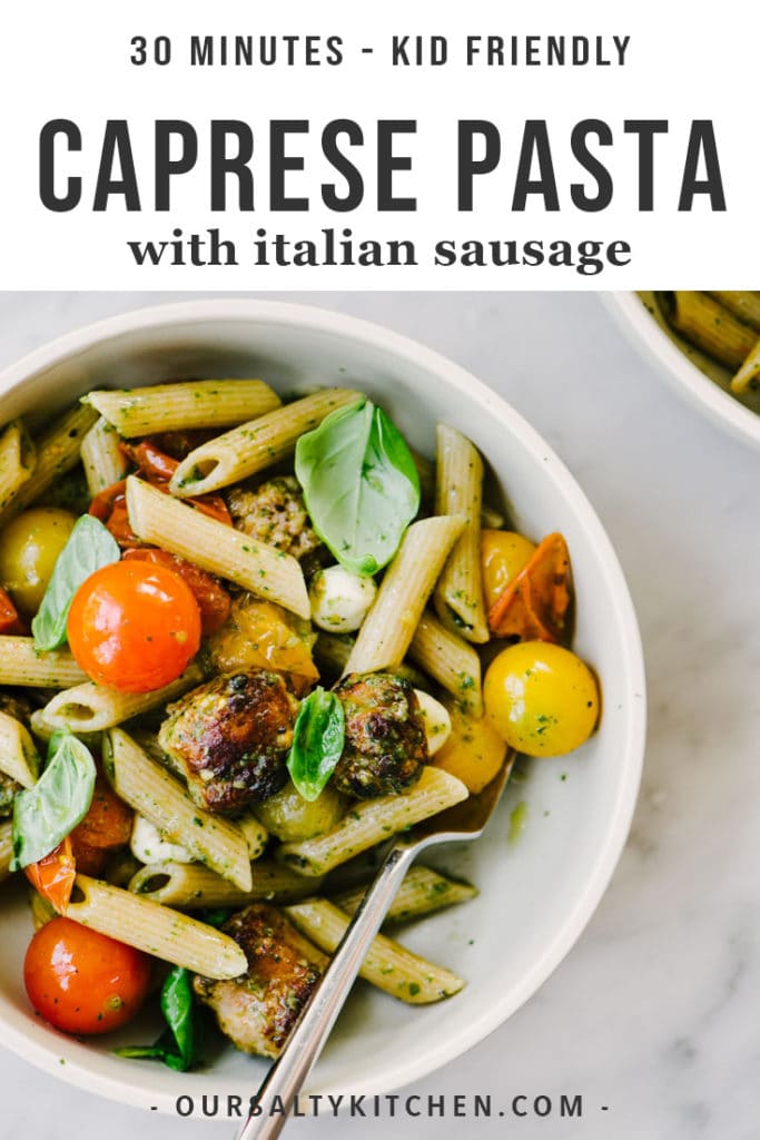 A bowl of caprese pasta with whole grain penne, italian sausage, burst tomatoes, fresh mozzarella, and nut free pesto dressing.