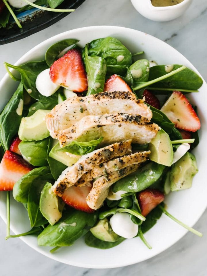 This strawberry chicken salad is a healthy, vibrant dinner recipe you'll crave again and again. This simple spring salad is made with smokey charcoal grilled chicken, sweet strawberries, avocados, and a creamy balsamic dressing. This dinner salad is fast (just 30 minutes), easy, and 100% addictive. Make it tonight!