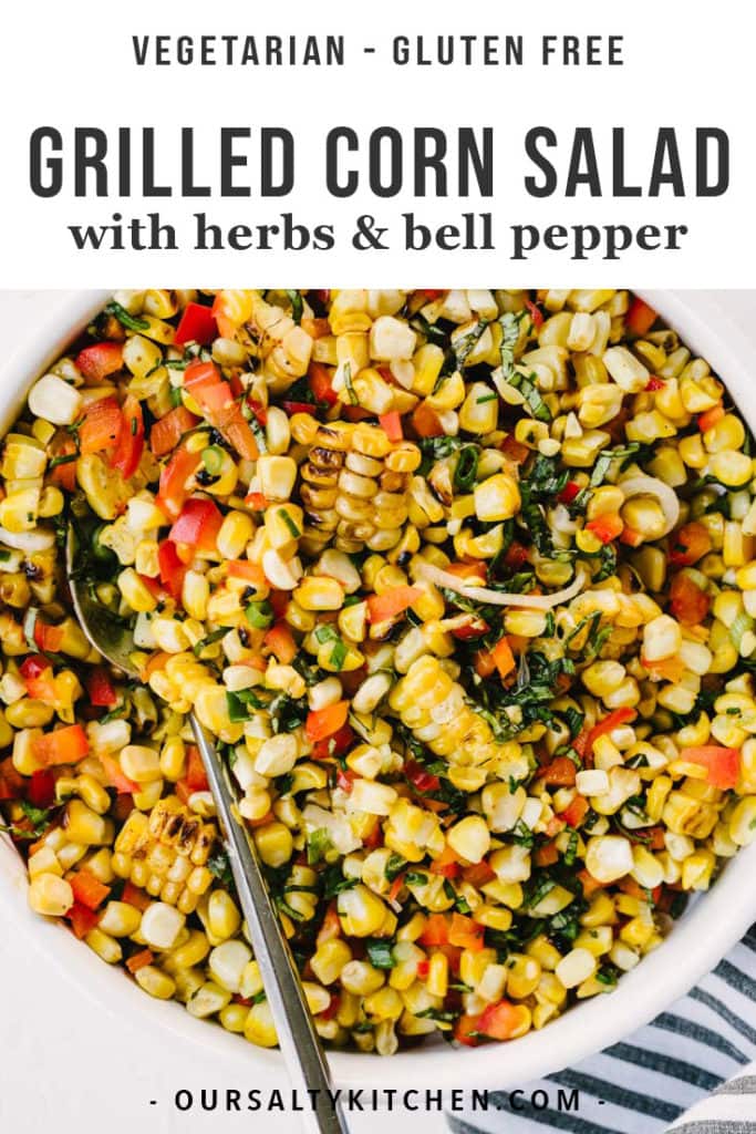 A bowl of grilled corn salad with herbs and bell peppers.