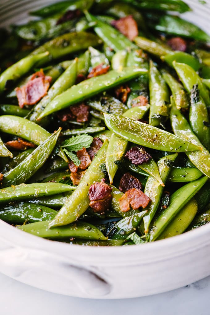 My favorite snap peas recipe! Sugar snap peas quickly sautéed with bacon and seasoned with fresh mint, lemon juice, and lemon zest.