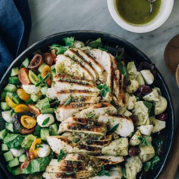 A salad platter filled with healthy mediterranean chicken salad with lemon herb oregano vinaigrette.
