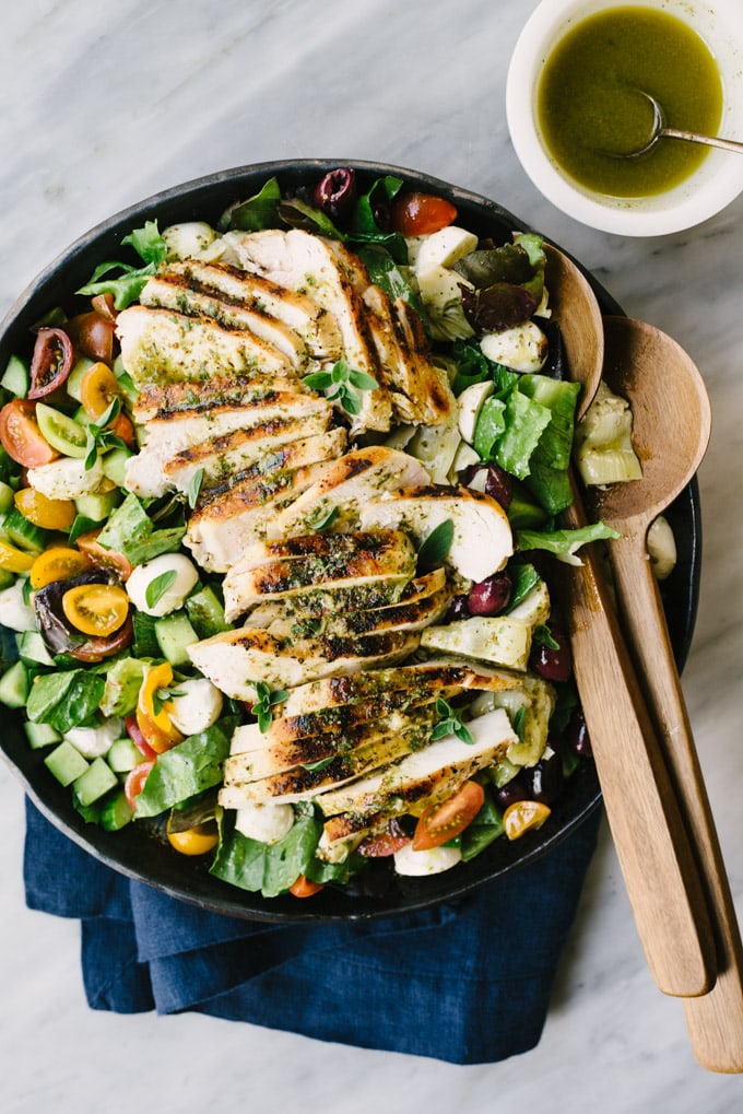 A salad platter filled with healthy mediterranean chicken salad with lemon herb oregano vinaigrette.