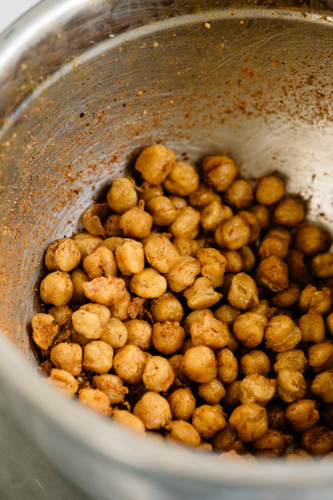 Chickpeas tossed with shawarma seasoning in a metal bowl.