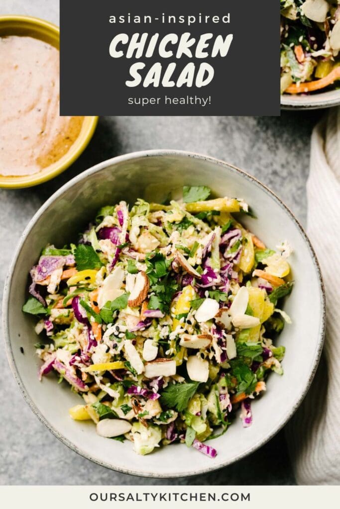 A bowl of healthy chicken salad with on a concrete background, with a small bowl of almond butter dressing to the side; title bar at the top reads "asian inspired chicken salad - super healthy!".