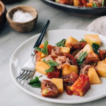 Cantaloupe and tomato salad with prosciutto, mint, and basil tossed with apple cider vinaigrette.
