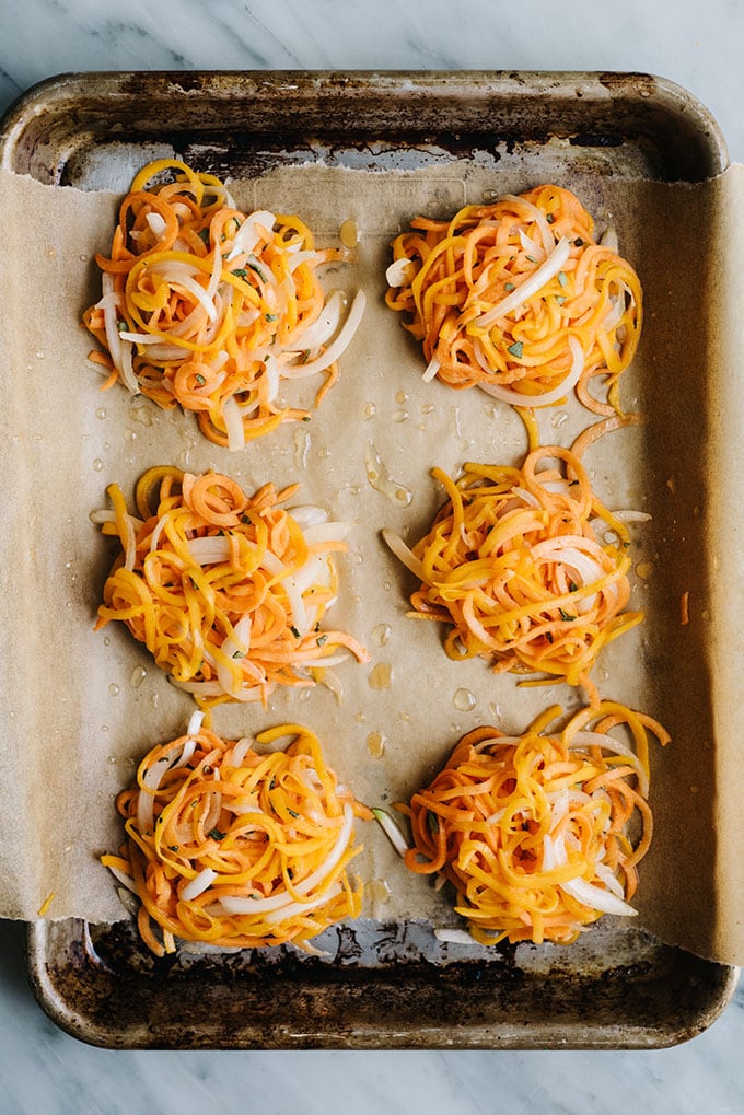 Mounds of butternut squash and sweet potato fritter batter on a baking sheet.