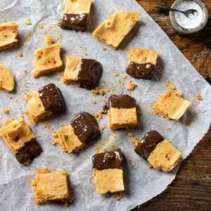 Homemade honeycomb candies dipped in chocolate on a piece of parchment paper.