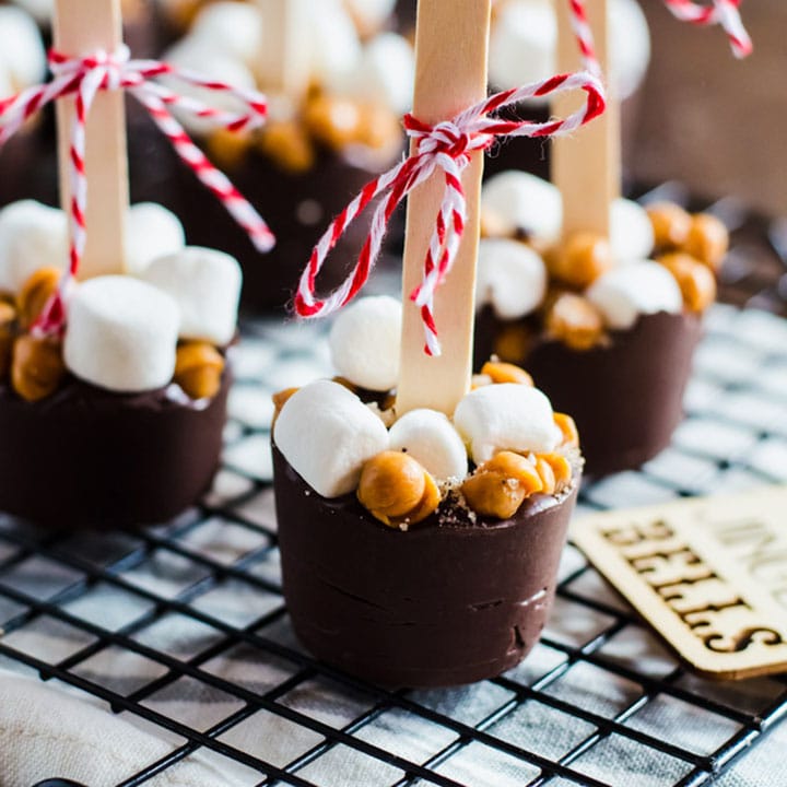 Hot chocolate on a stick seasoned with salted caramel and mocha arranged on a wire rack.