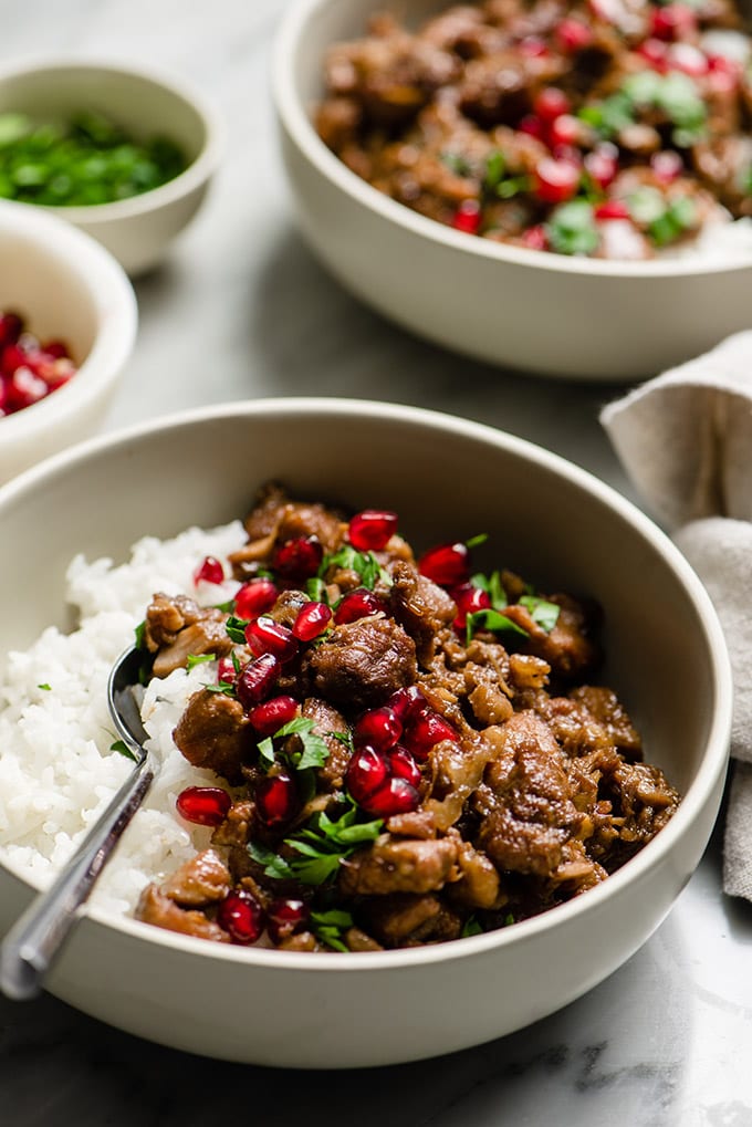 A bowl of paleo pomegranate chicken served over white rice, a healthy and easy gluten free dinner.