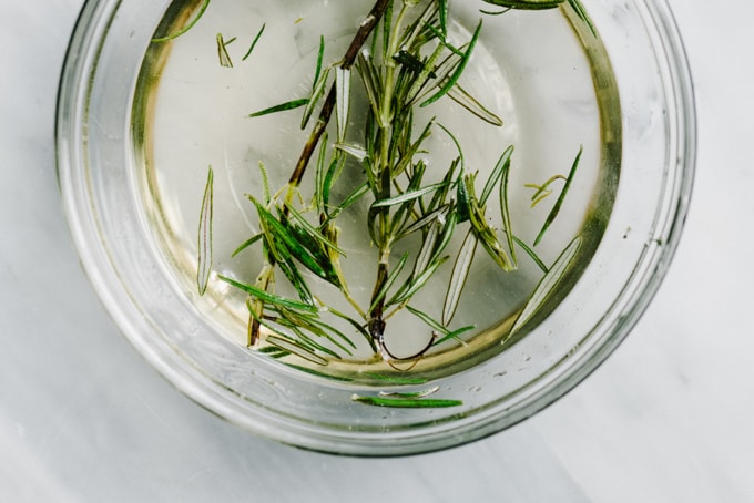 Rosemary infused simple syrup in a glass bowl.
