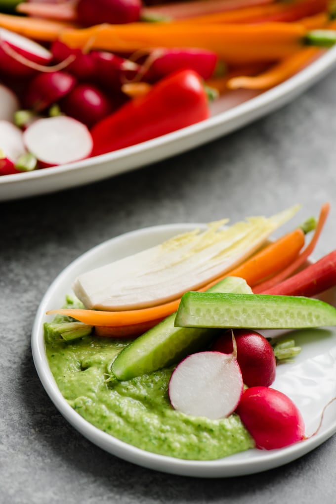 A small plate of crudite vegetables with white bean green goddess dip.