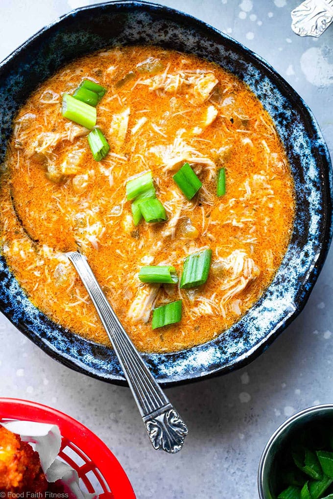 A bowl of low carb buffalo chicken whole30 soup garnished with green onions, cooked in the slow cooker.