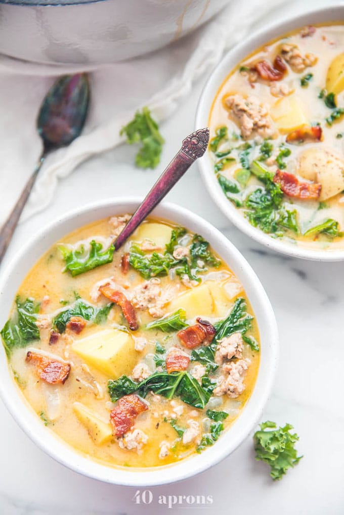 Two bowls of healthy zuppa toscana whole30 soup on a marble table. 