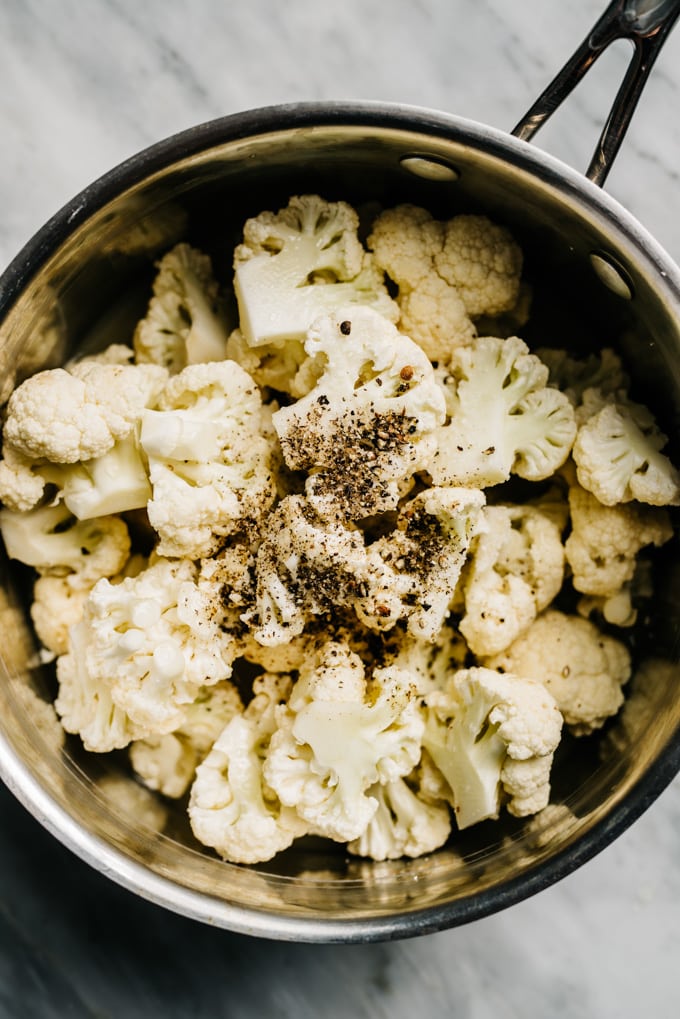 Seasoned cauliflower florets in a sauce pot for making cauliflower mash.