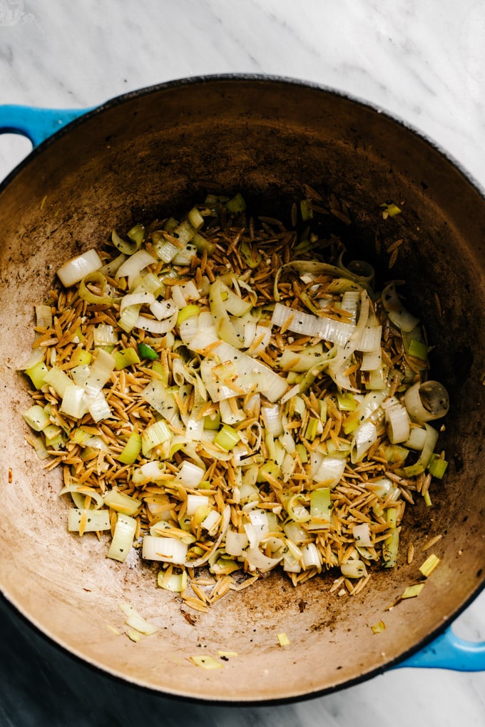 Sautéed leeks and garlic with toasted orzo in a dutch oven.