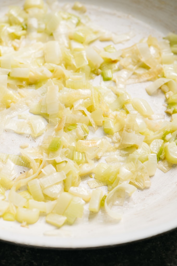Sautéed leeks and garlic in a skillet.