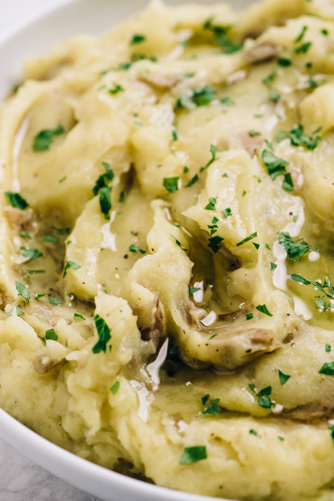 Side view, healthy mashed potatoes with olive oil and roasted garlic, garnished with chopped parsley.