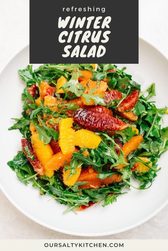 Citrus supremes tossed with arugula, mint, and orange vinaigrette in a large white serving bowl; title bar at the top reads "refreshing winter citrus salad".
