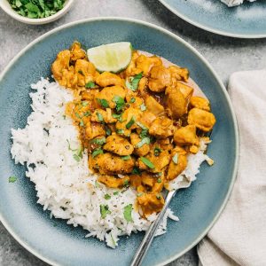 Instant Pot chicken curry served on a blue plate with rice