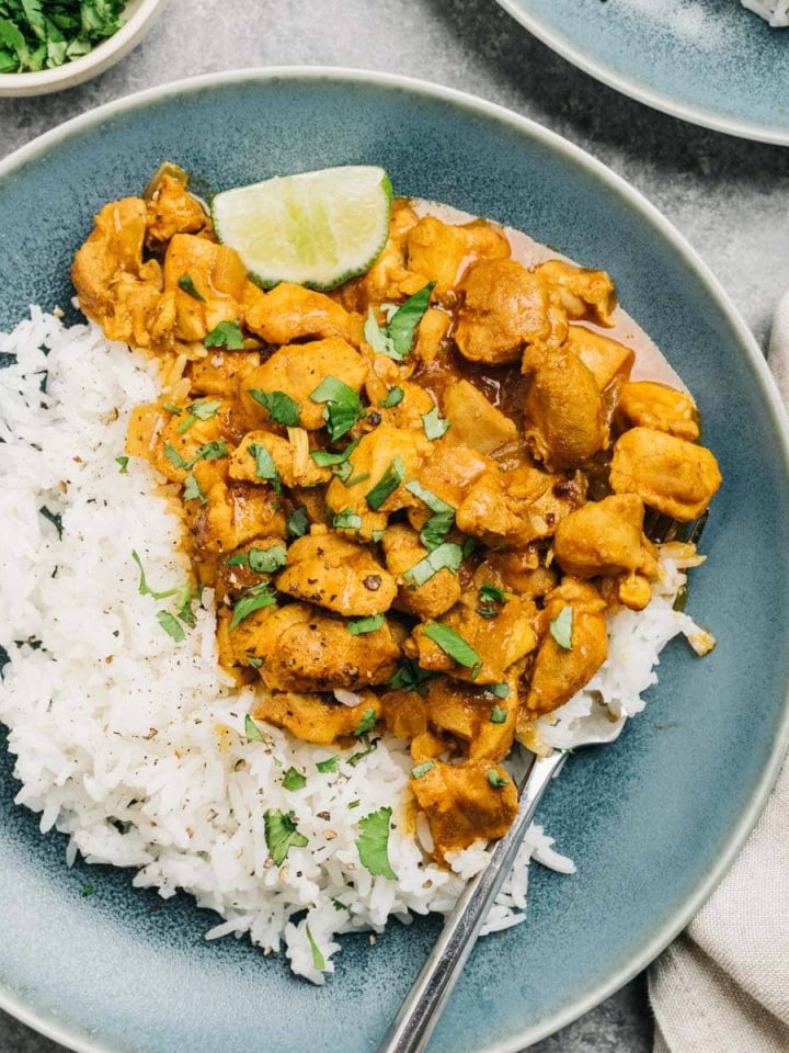 Instant Pot chicken curry served on a blue plate with rice