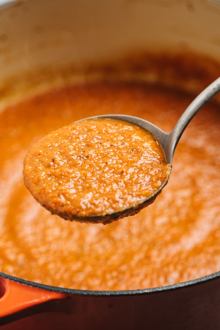 Marinara sauce on a ladle above a pot