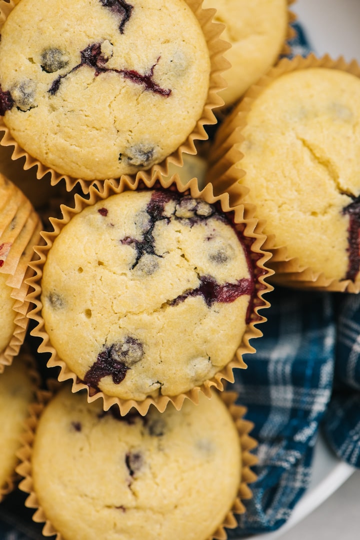 Blueberry muffins with cornbread on a blue kitchen towel.