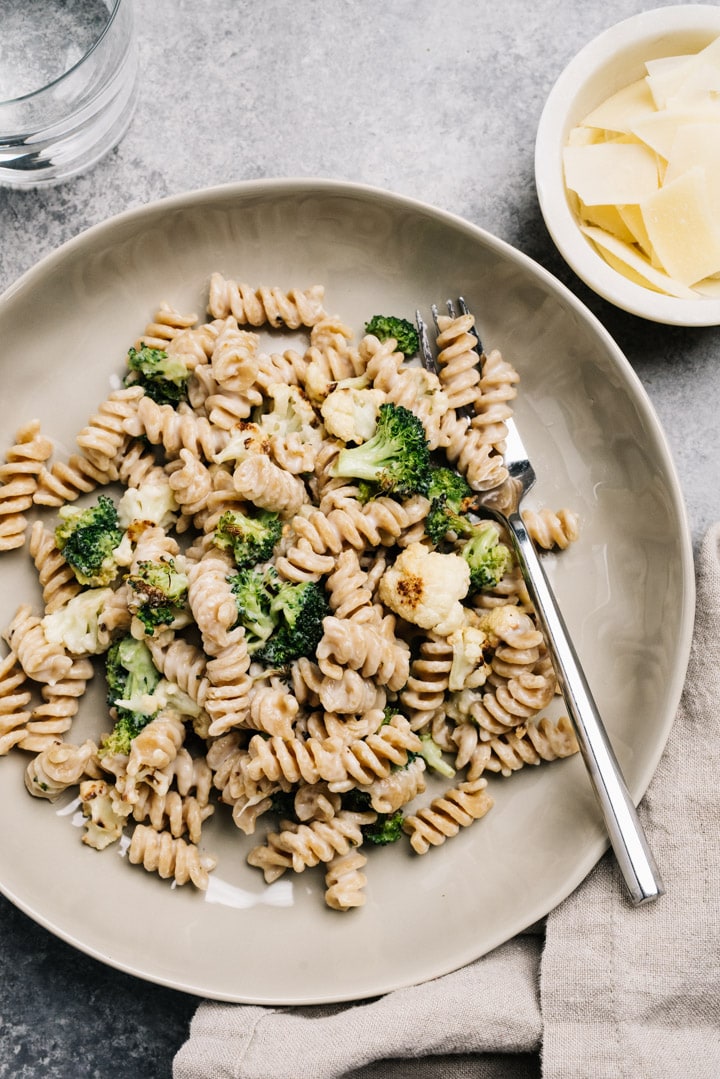 A bowl of whole wheat pasta tossed with creamy pasta sauce and roasted vegetables.