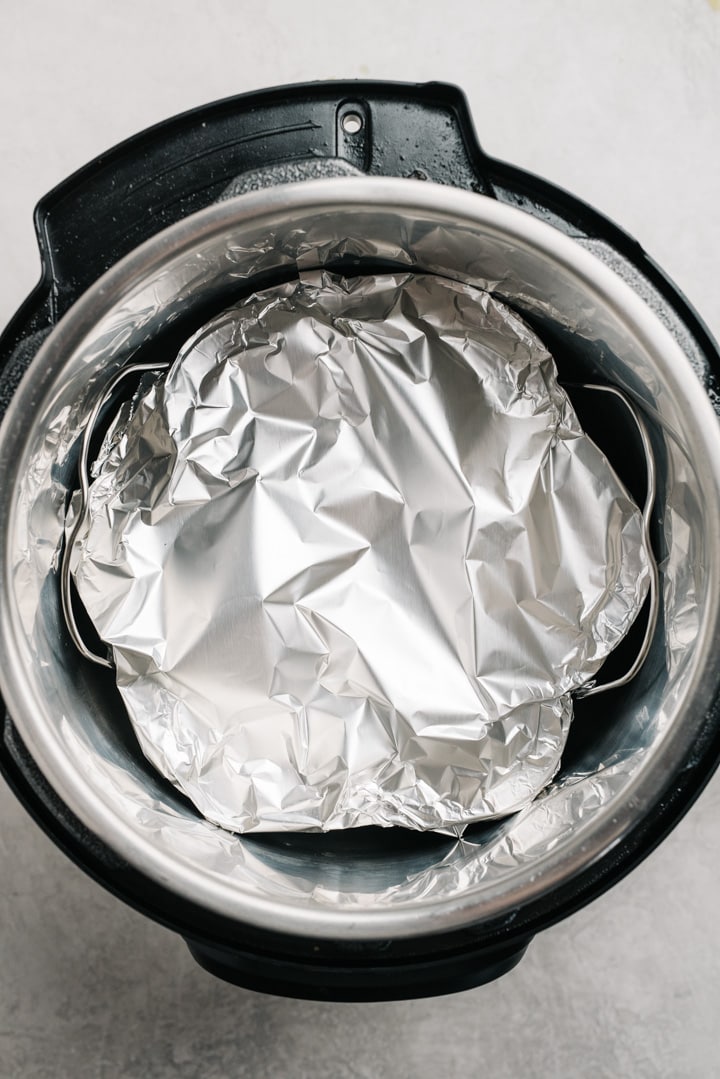 Egg bites mold covered in foil sitting in an Instant Pot.
