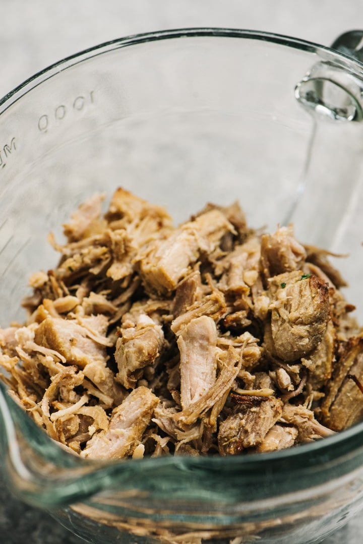 Leftover pulled pork in a glass storage container.
