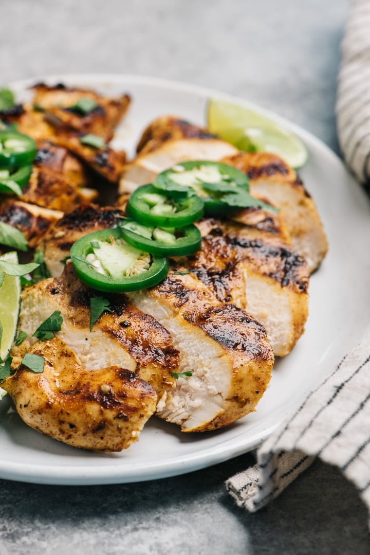 A plate of sliced grilled chicken seasoned with chili lime marinade.