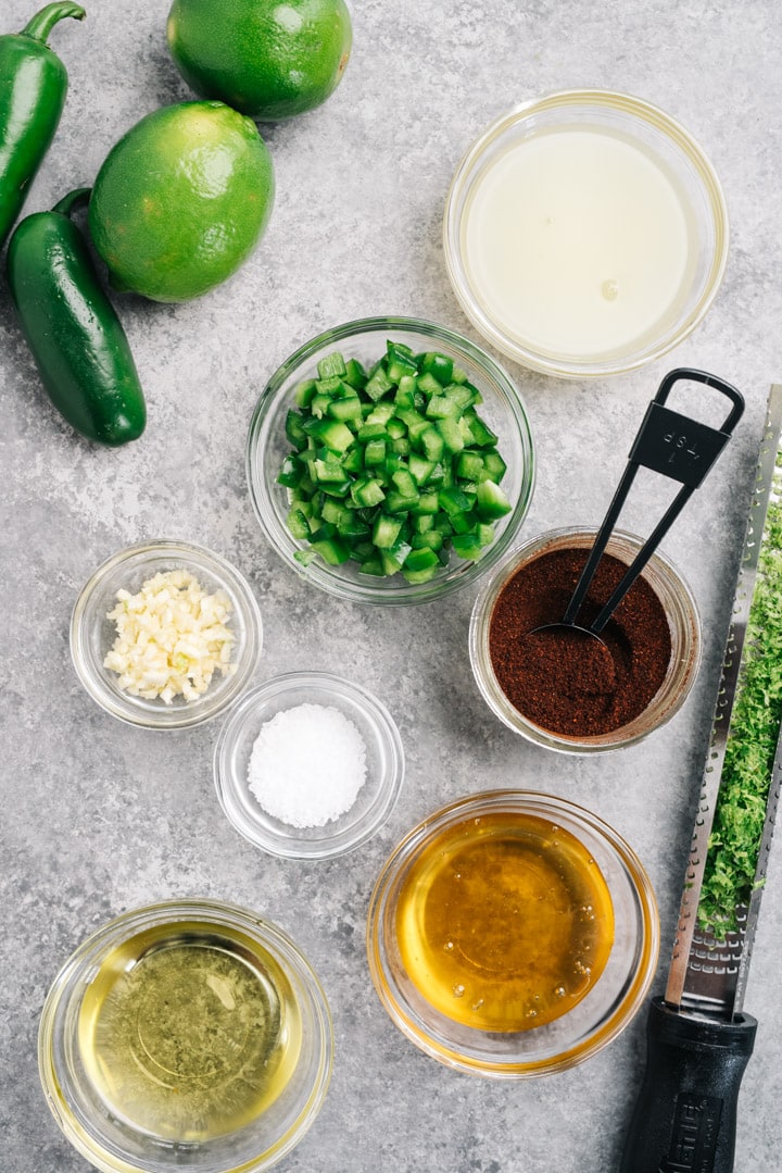 The ingredients for chili lime chicken marinade arranged on a cement background.