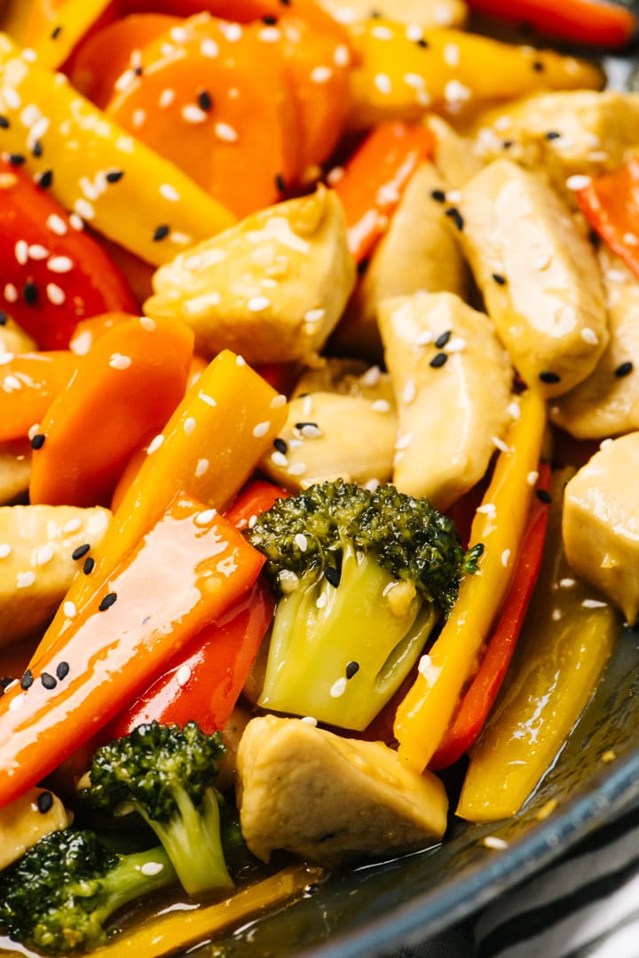 Side view of cooked chicken stir fry in a skillet.