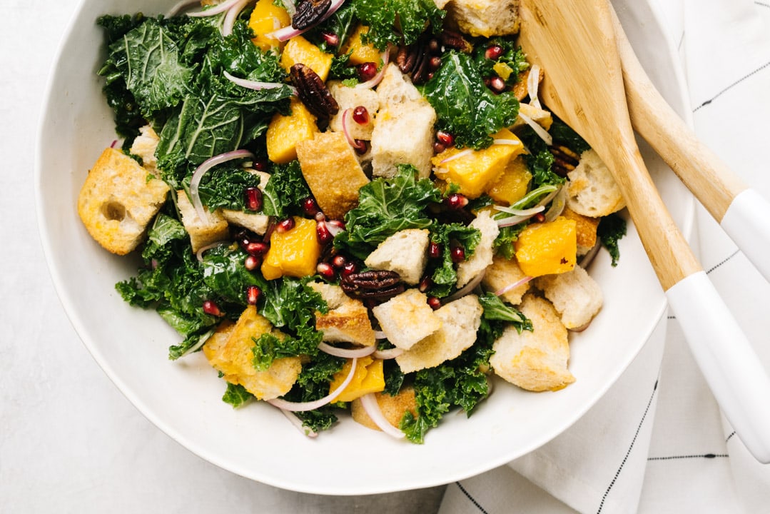 A white salad bowl filled with butternut squash panzanella salad.